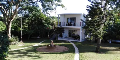 a white house with a tree in the yard at Villa Victoria in Sosúa