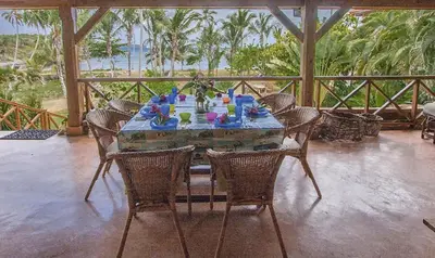a table on a porch with chairs and a table with at Villa Ibiscus in Las Galeras