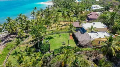 an aerial view of a house with palm trees and the ocean at Villa Caribeña in Las Galeras
