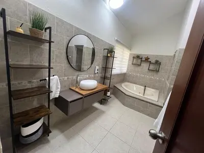 a bathroom with a sink and a tub and a mirror at Villa Guavaberry in Juan Dolio