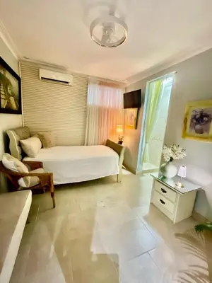 a bedroom with a bed and a chair in a room at Feair in Santo Domingo