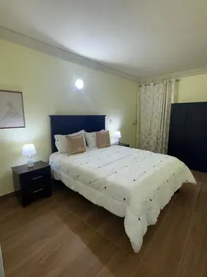 a bedroom with a large white bed with two lamps at Mi casa Amalia in Santa Cruz de Barahona