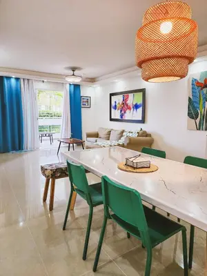 a living room with a table and green chairs at Cozy apartment Marea Azul in La Francia