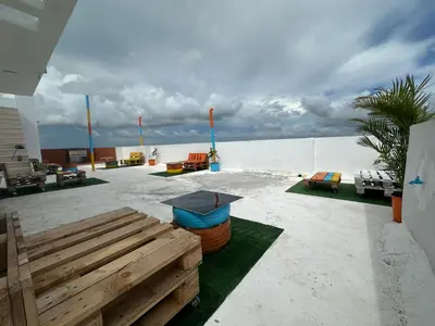 a patio with a bench and chairs on the beach at Apartamento Santo Domingo este in Juan López