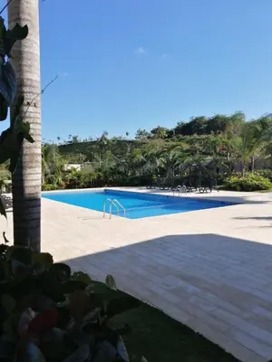 a swimming pool next to a beach with palm trees at Cozy retreat with luxurious feel in Santiago de los Caballeros