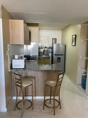 a kitchen with two bar stools and a counter top at Apartamento 2 Habitaciones BO in Santiago de los Caballeros