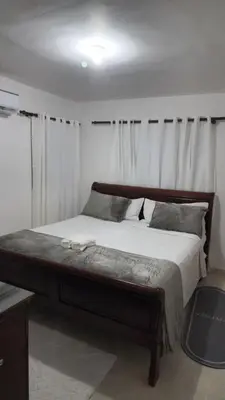 a bedroom with a large bed with white curtains at Beautiful Accommodation in La Romana Beach View in La Romana