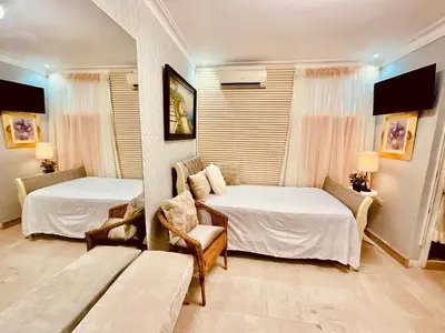 a hotel room with two beds and a couch at Jacqueline in Santo Domingo