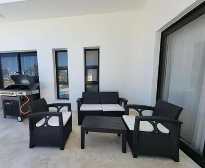 a living room with chairs and tables and a stove at Villa Tranquila - Sosua Ocean Village in Sosúa
