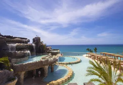 a resort with two pools and the ocean in the background at Villa Tranquila - Sosua Ocean Village in Sosúa