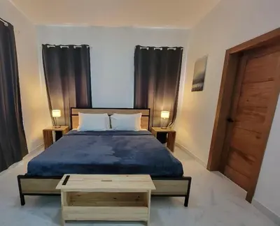 a bedroom with a bed with a blue comforter at Villa Tranquila - Sosua Ocean Village in Sosúa