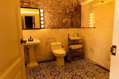 a bathroom with a white toilet and a sink at Casa Grullon, an Oasis in the Colonial Zone in Santo Domingo