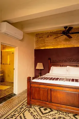 a bedroom with a bed and a ceiling fan at Casa Grullon, an Oasis in the Colonial Zone in Santo Domingo