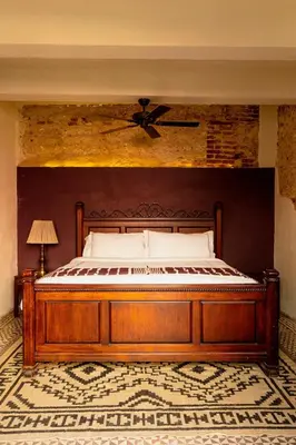 a bedroom with a large wooden bed with a ceiling at Casa Grullon, an Oasis in the Colonial Zone in Santo Domingo
