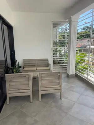 a room with two benches and a table and a balcony at Appartement cosy avec terrasse in Santa Bárbara de Samaná