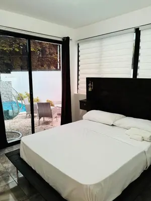 a bedroom with a large bed and a large window at El Rincón Soleado 1 in San Felipe de Puerto Plata