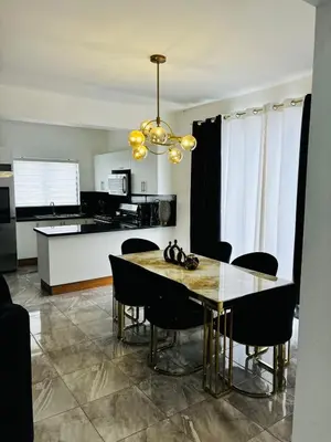 a kitchen and dining room with a table and chairs at El Rincón Soleado 1 in San Felipe de Puerto Plata