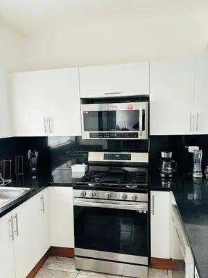 a kitchen with a stove and a microwave at El Rincón Soleado 1 in San Felipe de Puerto Plata