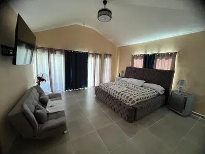 a bedroom with a bed and a couch and a television at Villa Barias in Las Calderas