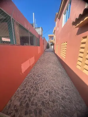 a long alley between two orange buildings at Villa Barias in Las Calderas