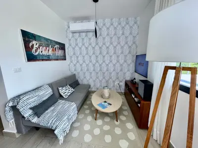 a living room with a couch and a table at Luxury Apt with Private Jacuzzi & Pool Near Beach in Las Terrenas