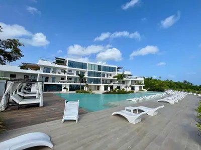 a resort with a swimming pool and white lounge chairs at Luxury Apt with Private Jacuzzi & Pool Near Beach in Las Terrenas