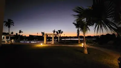 a palm tree and a gazebo at night at Las Cañas Playa Nueva Romana in El Soco