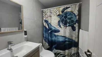 a bathroom with a shower curtain with a turtle on it at Las Cañas Playa Nueva Romana in El Soco