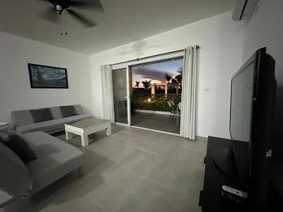 a living room with a couch and a television at Las Cañas Playa Nueva Romana in El Soco