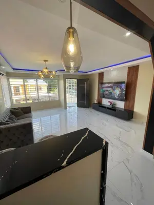 a large living room with a couch and a tv at Apartamento in Cancino