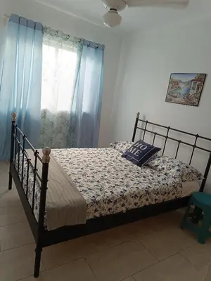 a bedroom with a bed with blue curtains at Apartment in Riviera Colonial in Calero