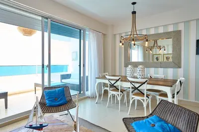 a dining room and living room with a table and chairs at Escape Beachfront Condos Las Olas Juan Dolio in La Puntica de Juan Dolio