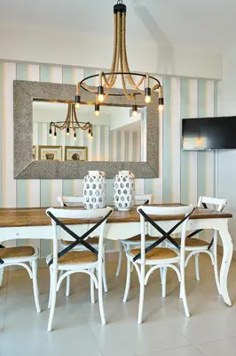 a dining room with a table and chairs and a mirror at Escape Beachfront Condos Las Olas Juan Dolio in La Puntica de Juan Dolio
