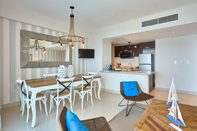 a dining room and kitchen with a table and chairs at Escape Beachfront Condos Las Olas Juan Dolio in La Puntica de Juan Dolio