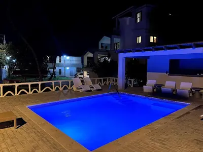 a swimming pool at night with chairs around it at Front Beach Punta Rucia Villa in Punta Rucia