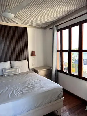 a bedroom with a bed and a large window at Front Beach Punta Rucia Villa in Punta Rucia