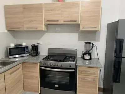 a kitchen with a stove and a microwave at Juan Bosch apartament in Santo Domingo
