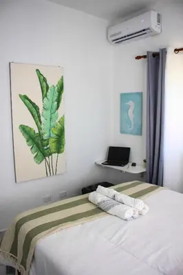 a bedroom with a bed and a laptop on a desk at Residencia Bambou HAVRE DE PAIX in Juan Dolio