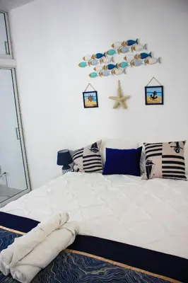 a bedroom with a large white bed with pillows and a starfish at Residencia Bambou HAVRE DE PAIX in Juan Dolio
