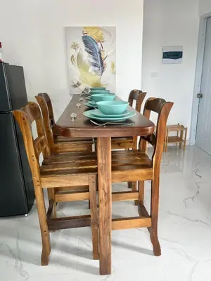 a dining room table with wooden chairs and blue dishes at Residencia Bambou HAVRE DE PAIX in Juan Dolio