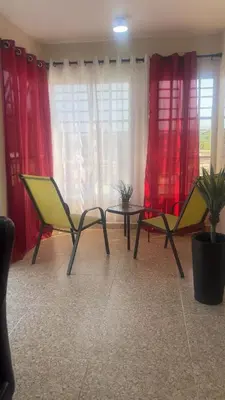 two chairs and a table in a room with red curtains at SDQ Apartment Marbella 4 in La Ureña