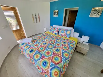 a bedroom with a large bed with a colorful comforter at Beachfront Villa Tabiki at Playa Coson, Las Terrenas, Dominicana in Las Terrenas