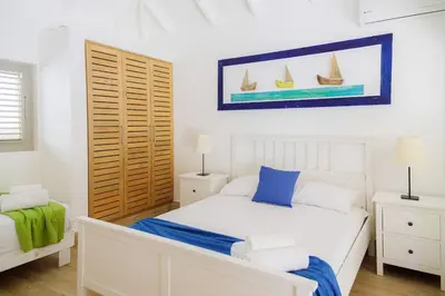 a bedroom with a bed with two night stands and two lamps at Beachfront Villa Tabiki at Playa Coson, Las Terrenas, Dominicana in Las Terrenas