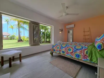 a bedroom with a bed and a large window at Beachfront Villa Tabiki at Playa Coson, Las Terrenas, Dominicana in Las Terrenas