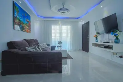 a living room with a couch and a flat screen tv at America Apartment in Santo Domingo