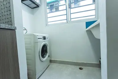 a washing machine in a bathroom with a window at America Apartment in Santo Domingo
