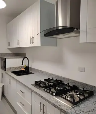 a kitchen with a stove top and white cabinets at Bayahibe Rose C - Gray Elegance in San Rafael del Yuma