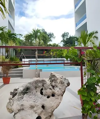 a rock on the floor of a building with a pool at Bayahibe Rose C - Gray Elegance in San Rafael del Yuma