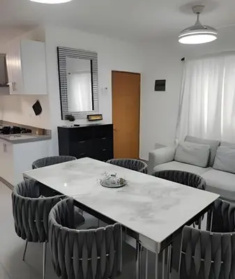 a kitchen and living room with a table and chairs at Bayahibe Rose C - Gray Elegance in San Rafael del Yuma