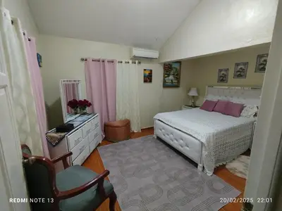 a bedroom with a white bed and a chair at Residencial Oasis in Juan López